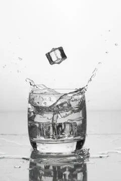 Water with ice in a glass with splashes Stock Photos