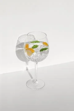 Water with ice lemon and mint leaves in wine glass, vertical shot 스톡 사진