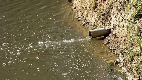 Water inflow through plastic pipe into pond Stock Footage 120555735
