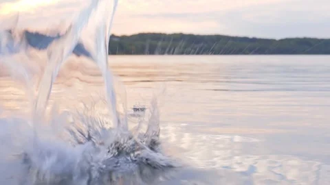 Water jet hits on surface of water, droplets sprayed over a lake Видео 129605827