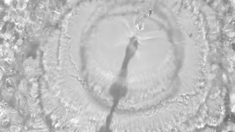 Water jet hitting surface, creating detailed ripple formations and symmetrical Stock Footage 311319950