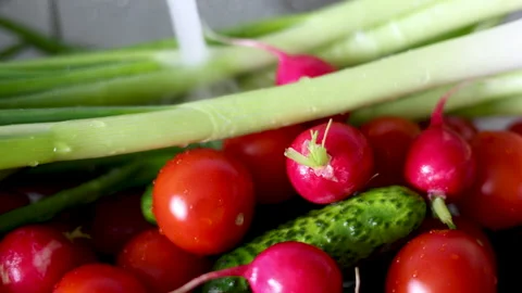 Water jet pouring flows over fresh vegetables in kitchen sink. Stock-Footage 242990835