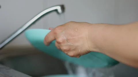 Water jet pouring flows over fresh vegetables in kitchen sink. Stock-Footage 242990837