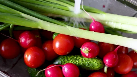 Water jet pouring flows over fresh vegetables in kitchen sink. Stock-Footage 242990843