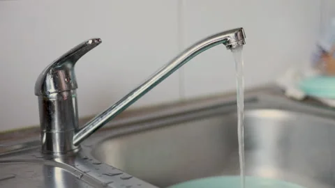 Water jet pouring flows over fresh vegetables in kitchen sink. Stock-Footage 242990871