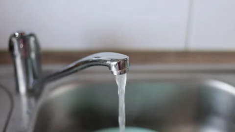 Water jet pouring flows over fresh vegetables in kitchen sink. Stock-Footage 242990873