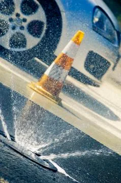 Water jets on car testing proving ground, pylon and vehicle in background Stock Photos