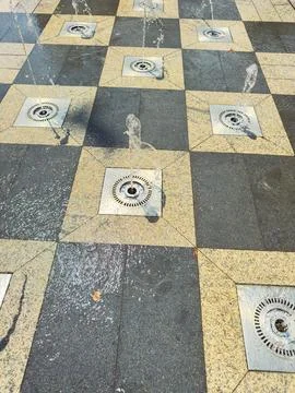 Water jets create patterns on the ground in a square layout at a public spa.. Stock Photos