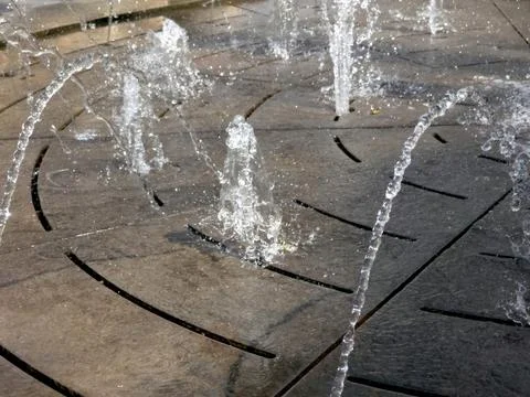 Water Jets Pattern a Stone Surface in an Outdoor Fountain During the Day Stock Photos