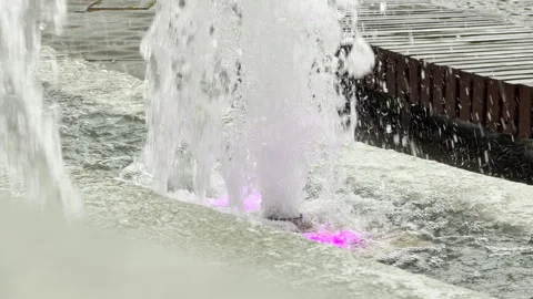 Water jets spray upward inside an illuminated city park fountain. Stock Footage 336363634