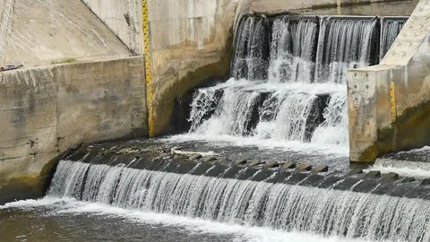 Water from large dams in large quantities hits the rocky shore hard. Stock Footage 278634645