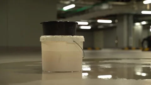 Water leaking from ceiling in parking garage dripping into a bucket Stock Footage 320255464