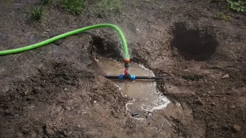 Water is leaking from damaged irrigation system need repair. A puddle has formed Stock Footage 194396555