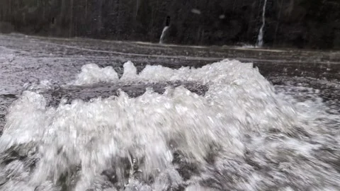 Water leaking from a manhole during a storm Stock Footage 313113961