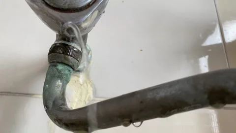 Water leaking from pipe on white wall at home kitchen sink repair and fix Stock Footage 248886276