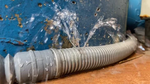 Water leaking from plastic pipe on ground. Splashing water leak. Video stock 295510533