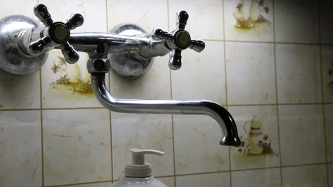 Water leaking from tap in the wall Vidéo 123700403