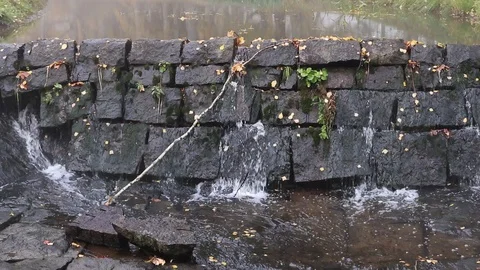 Water leaking through stone dam construction Stock Footage 117576255
