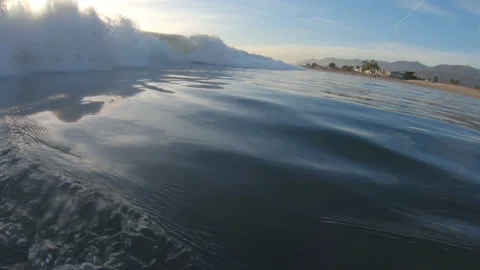 Water Level Footage Looking Down the Coastline While a Wave Approaches Stock Footage 208763047