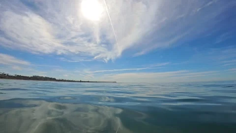 Water Level View of Oceanside Pier and Coastline Under Bright Sun Stock Footage 331615850