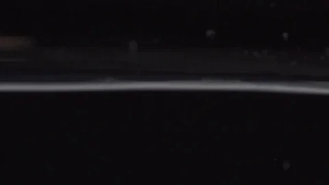 Water line closeup on black background in slow motion Stock Footage 73354801