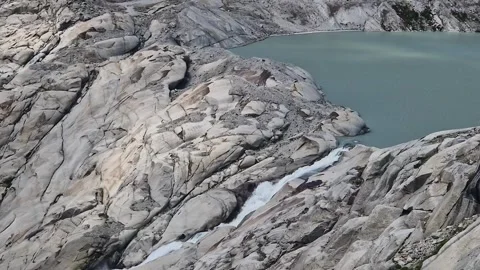 Water from the melting rhone glacier creating a river flowing into a turquoise Stock Footage 340920722