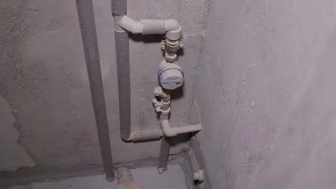 A water meter within a plumbing setting. The dusty pipes, fittings, and valves. Video stock 294174056