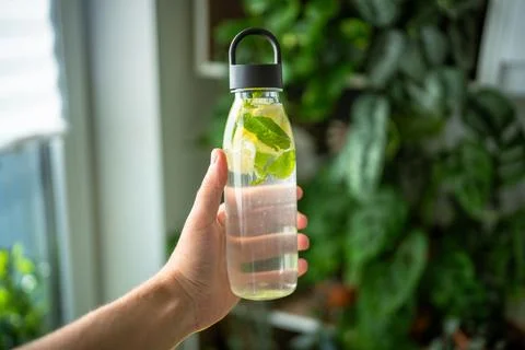 Water with mint, thyme, lime for drinking outside in hot weather, bottle wi.. Stockfoto's