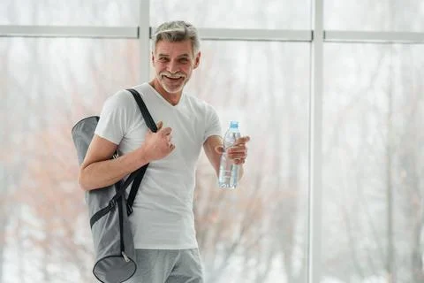 Water is the most important nutrient for active people. Senior man holding bo Stock Photos