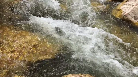 Water from the mountain flows between the stones in close-up Stock Footage 138159574