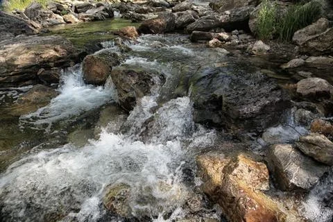 Water of mountain river flows down from the rocks Stock Photos