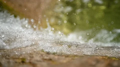 Water from a mountain stream falls over rocks (slow motion, direct sunlight) Stock-Footage 219635189