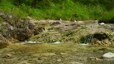 Water from a mountain stream flowing over rocks Video stock 211469757