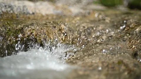 Water from a mountain stream flows over rocks in summer (slow motion) Stock-Footage 219634846
