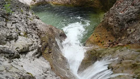 Water from a mountain stream flows into a pool Video stock 211467424