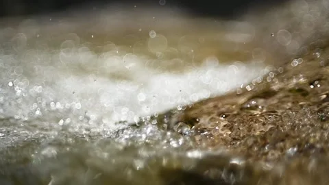 Water from a mountain stream flushing into a pool (bokeh, slow motion) Stock Footage 219641450
