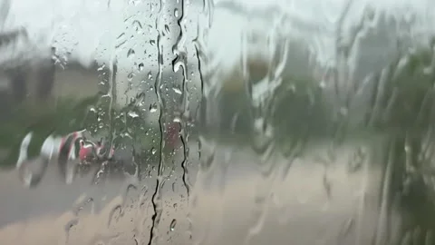 Water moves across the window of a moving vehicle with a road and passing traffi Stock Footage 338001710
