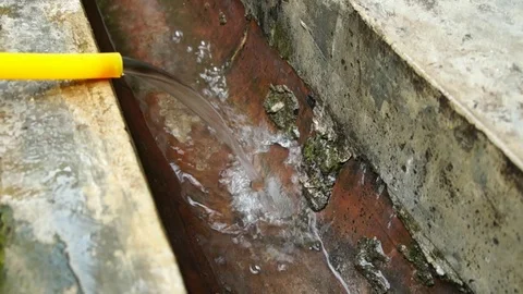Water non-stops flow out from yellow rubber hose to the drain. Stock Footage 111564301