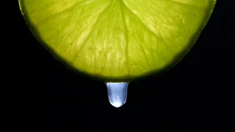 Water or oils dropping on a Lime slice on black background in slow motion Stock-Footage 126257127