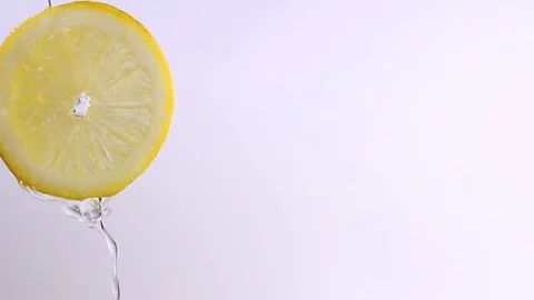 Water or oils falling on a lemon wedge, fruit for diet and healthy food, summ Stock Footage 128896596