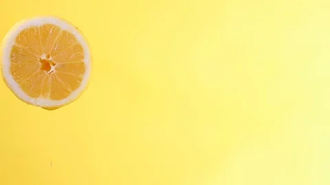 Water or oils falling on a lemon wedge, fruit for diet and healthy food, summ Stock Footage 128896682