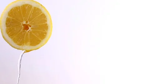 Water or oils falling on a lemon wedge, fruit for diet and healthy food, summ Stock Footage 128896695