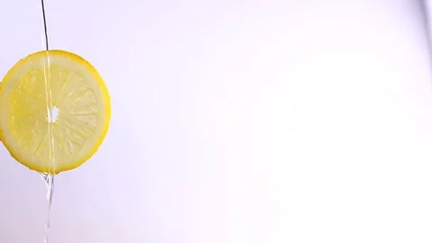 Water or oils falling on a lemon wedge, fruit for diet and healthy food, summ Stock Footage 128896697