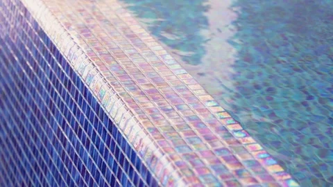 Water overflowing the edge of an infinity pool with blue mosaic tiles. Stock-Footage 333688267
