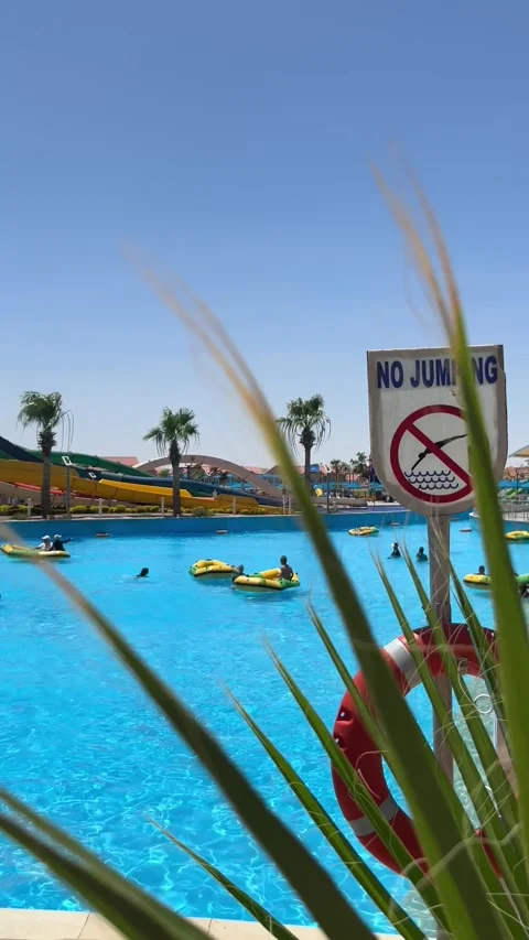 Water park pool with no jumping sign and inflatable floats on June 20, 2026 in Stock Footage 337293735