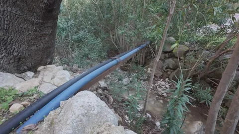 Water Pipes Crossing Forest Stream Showing Human Impact on Natural Landscape Stock Footage 338105426