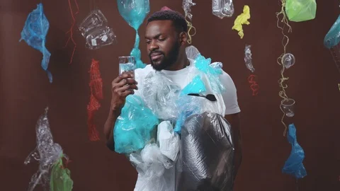 Water pollution. Black serious guy eco activist wearing plastic and refusing to Stock Footage 124550126