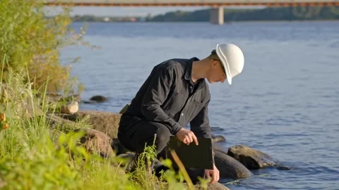 Water Pollution Testing at Riverside by Environmental Scientist Stock Footage 321726578