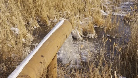 Water pollution. Wastewater is discharged through a rusty sewer into a body of Stock Footage 123772104