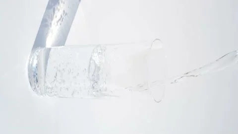 Water is poured into a glass on light background, close up. Stock Footage 166768088